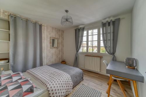 a bedroom with a bed and a desk and a window at Chic and modern house with parking garden and gym in Saint-Denis