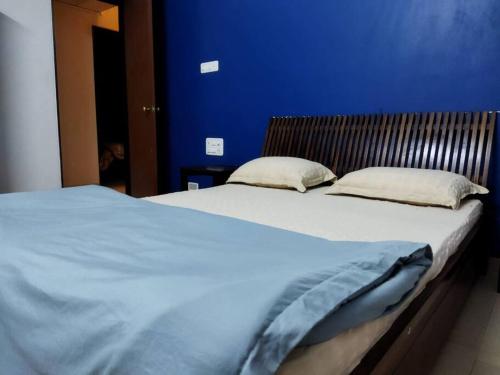 two beds in a bedroom with a blue wall at 3BHK Luxury House near Calangute/Bagha(C4) in Anjuna