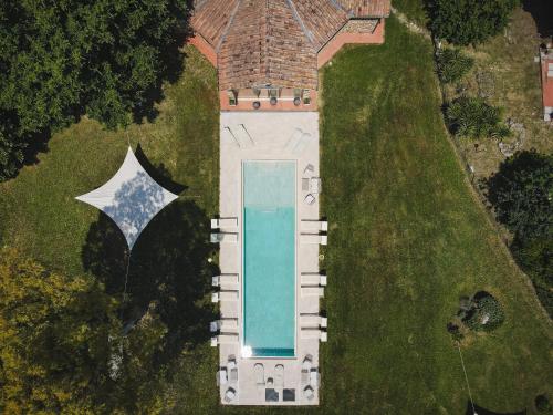 una vista aérea de una casa con piscina y sombrilla en Relais Ciavatta Country Hotel en Montemerano