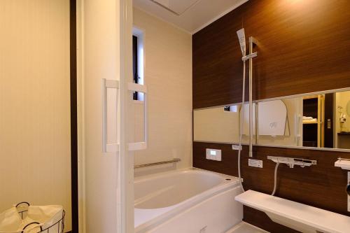 een badkamer met een bad en een wastafel bij Sense of wonder Yufudake Sanroku Glamping Resort - Vacation STAY 41961v in Yufu