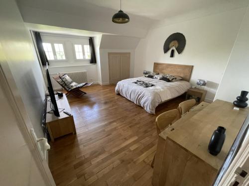 une chambre avec un lit et une table dedans dans l'établissement VILLA DE 450M2 POUR 15 PERS 15 MN DISNEYLAND PARIS ET 45MN PARIS AVEC GRAND JARDIN, à Mareuil-lès-Meaux