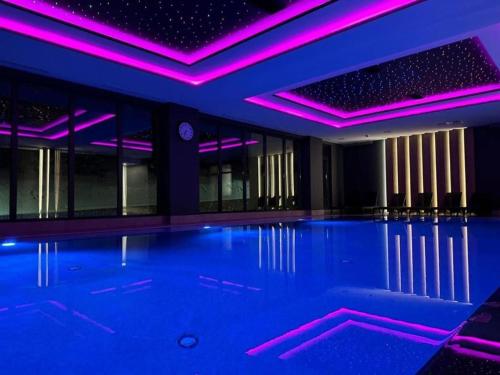 una piscina cubierta con iluminación púrpura en Aparthotel Zlatni Javor - Apartman 511, en Jahorina