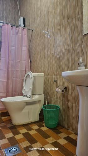 a bathroom with a toilet and a sink at Puma Aparthotel - Nyarutarama in Kigali