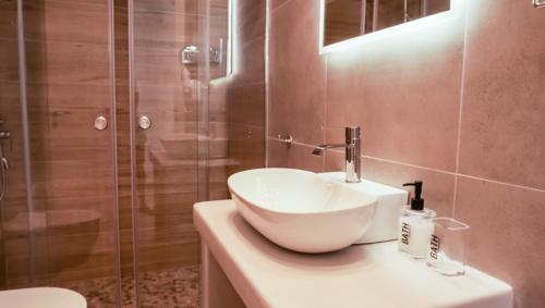 a bathroom with a sink and a shower at ΟTTO apts in Loutrá