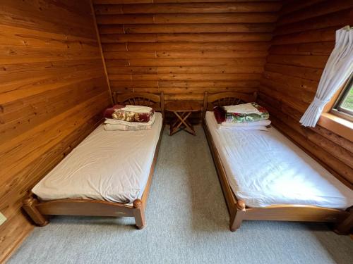 Nasu Takahara Auto Campsite - Vacation STAY 42064v في ناسوشيوبارا: غرفة بسريرين في كابينة خشب