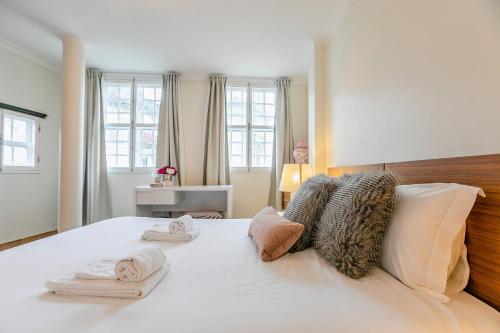 a bedroom with a white bed with towels on it at Spacious Duplex Apartment in the heart of Porto in Porto