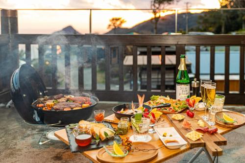 stół z jedzeniem oraz butelkę wina i napojów w obiekcie Minamiizu Yuhigaoka Camp Site - Camp - Vacation STAY 42067v w mieście Ihama