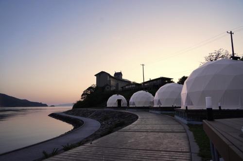 rząd kopuł i namiotów przy wodzie w obiekcie TADAYOI - Sea Glamping - Camp - Vacation STAY 42099v 
