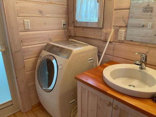 y baño con lavabo y lavadora. en Camp inn Kiyosato GRANDEUR - Vacation STAY 42082v en Hokuto