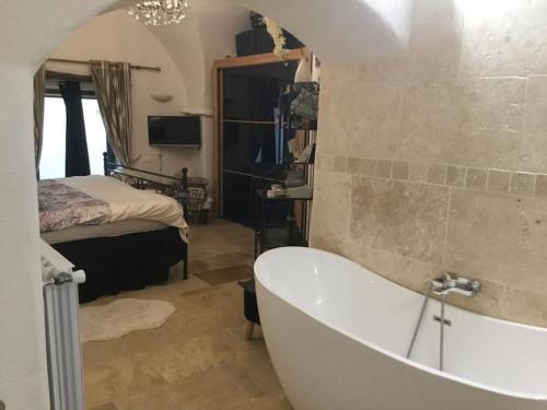 a bathroom with a tub and a bedroom with a bed at La Stala in Pieve di Teco