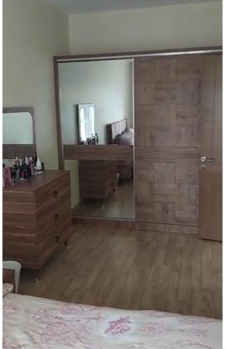una camera da letto con cassettiera e grande specchio di st home a İkitelli