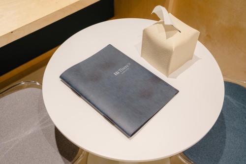a white table with a book and a paper bag on it at Hithere City Myeongdong in Seoul