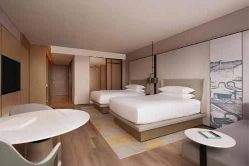 a hotel room with two beds and a table at Shantou Marriott Hotel in Shantou