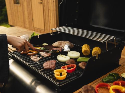 una persona cocinando carne y verduras en una parrilla en HOLE37 - Vacation STAY 42201v, 