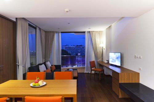 a living room with a table and a living room with a view at Eastin Tan Hotel Chiang Mai in Chiang Mai