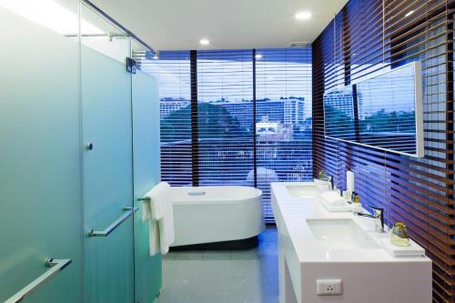 a bathroom with two sinks and a large window at Eastin Tan Hotel Chiang Mai in Chiang Mai
