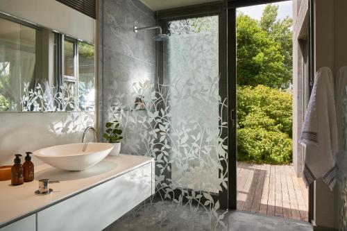 a bathroom with a sink and a glass shower at Spanish Farm Boutique Hotel & Villas in Somerset West