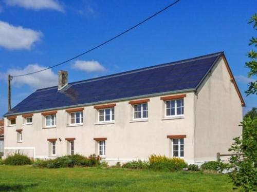 a large white house with a black roof at grand gîte à la campagne in Couvains