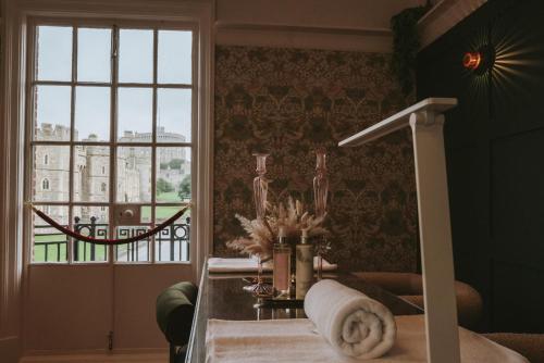 a room with a window and a table with towels at Luxury, Castle View Apartment! Spa Treatments , Windsor Town Centre in Windsor