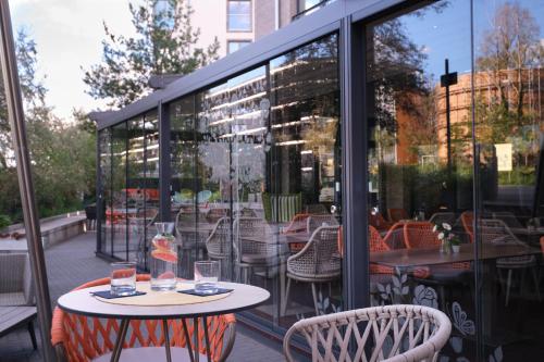 a patio with a table and chairs and windows at Grimm's Potsdamer Platz in Berlin