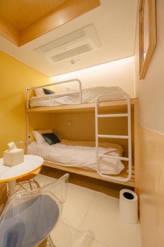 a room with two bunk beds and a table at Hithere City Myeongdong in Seoul