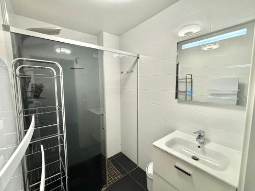 une salle de bain blanche avec un lavabo et une douche dans l'établissement Appartement L'Ambiente 2 PORTICCIO, à Porticcio