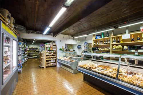 a store aisle of a grocery store with shelves of food at Estivo Premium Deluxe mobile homes on Camping Del Sole Village in Iseo