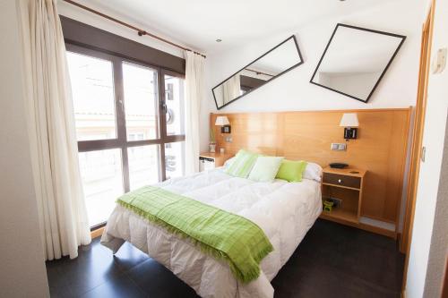 a bedroom with a bed and a large window at Hotel Real de Illescas in Illescas