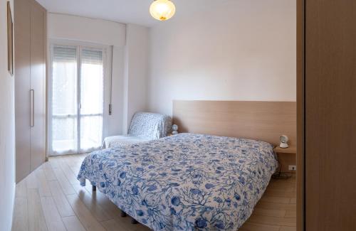 a bedroom with a bed and a chair and a window at il Golfo di Diana in Diano Marina