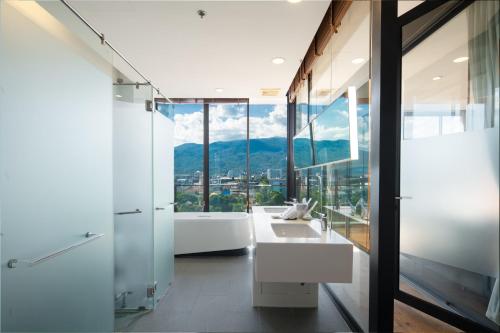a bathroom with a sink and a large window at Eastin Tan Hotel Chiang Mai in Chiang Mai