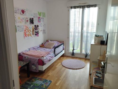een slaapkamer met een bed in een kamer bij Superbe appartement avec 3 chambres à 700 mètres du stade de France in La Plaine-Saint-Denis