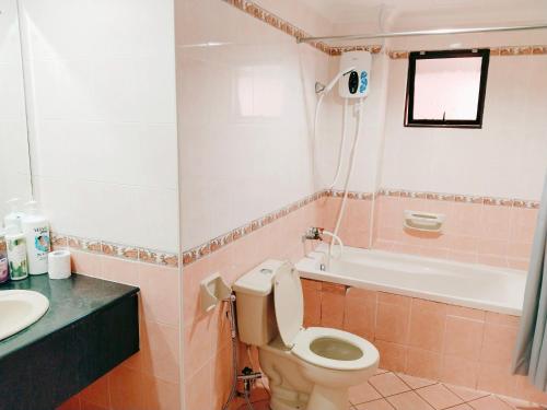 a bathroom with a toilet and a sink and a bath tub at Maricel homestay in Kota Kinabalu