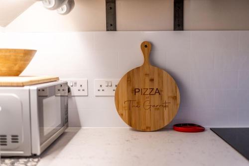 a wooden cutting board on the wall of a kitchen at The Garret in Salisbury