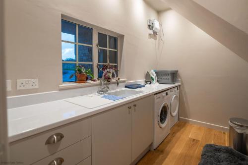 a kitchen with a sink and a washing machine at The Garret in Salisbury