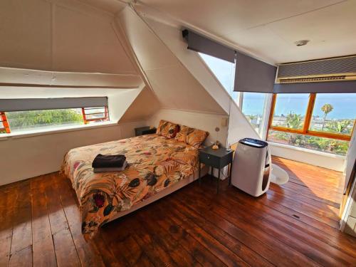 a bedroom with a bed in a room with windows at Mosselbay Dream Home in Mossel Bay
