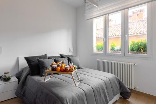 a bed with a tray of fruit on it at La dimora degli asinelli in Bologna