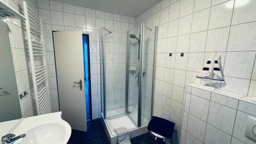 a bathroom with a shower and a sink at Huus Achterdiek - Whg Anker in Dornumersiel