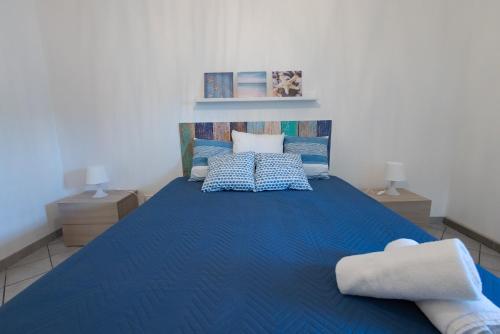 a bedroom with a blue bed with two night stands at Villa Al Mare Guest House in Tre Fontane