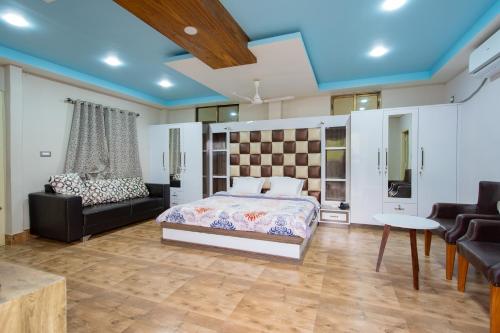 um quarto com uma cama e um sofá em RaDiant Club & Resort em Imphal