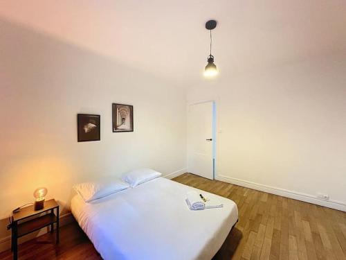 ein Schlafzimmer mit einem großen weißen Bett und einem Tisch in der Unterkunft Cosy Appartement, Lyon 6è Barrier in Lyon