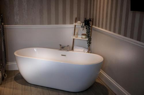 a white bath tub sitting in a bathroom at Cumbria Park Hotel in Carlisle