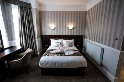 a hotel room with a bed and a desk at Cumbria Park Hotel in Carlisle