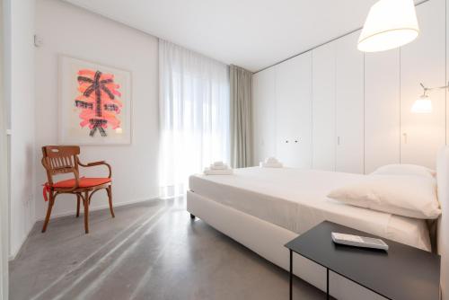 1 dormitorio con 1 cama grande y 1 silla roja en Villa Vogue - IsulaTravel, en Avola