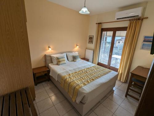a bedroom with a large bed and a window at Pagaseon Rooms and Apartments in Kala Nera