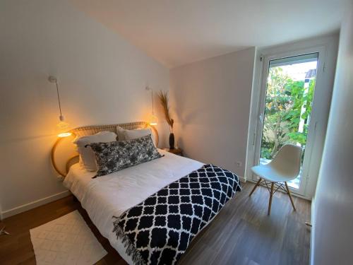 une chambre avec un lit noir et blanc et une fenêtre dans l'établissement Villa quartier des fleurs 5 min Canet, à Canet