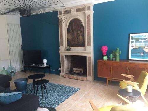 Grande maison #6 chambres #Proche Amboise/Tours في Mosnes: غرفة معيشة مع جدران زرقاء ومدفأة