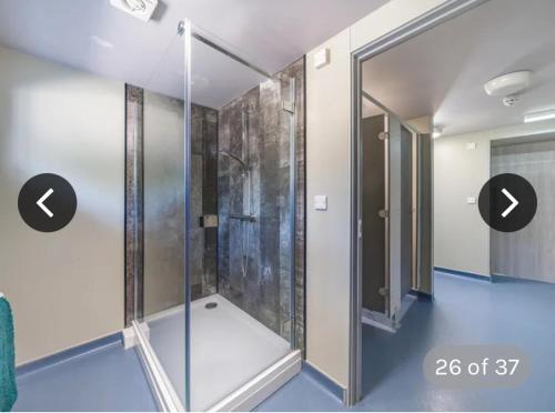 een douche met een glazen deur in een kamer bij Immaculate 6-Bed Ivy house in Doncaster