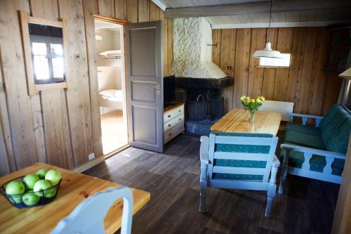 a living room with a table and a stove at Hunderfossen Cottages in Hafjell