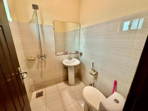 La salle de bains est pourvue de toilettes et d'un lavabo. dans l'établissement Shelton Hotel Lahore, à Lahore