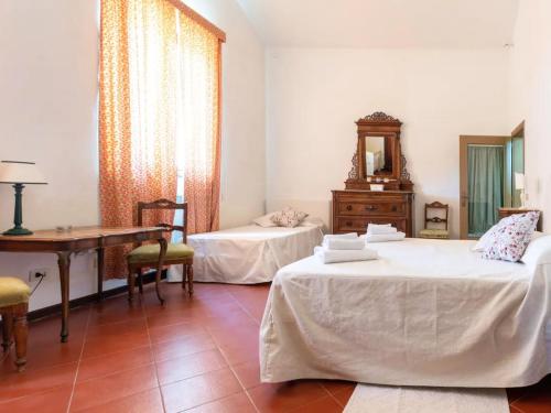 een kamer met 2 bedden, een tafel en een bureau bij Fienile in Castelnuovo Berardenga